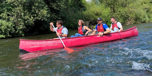 One Canoe on the River with 4 people sitting in