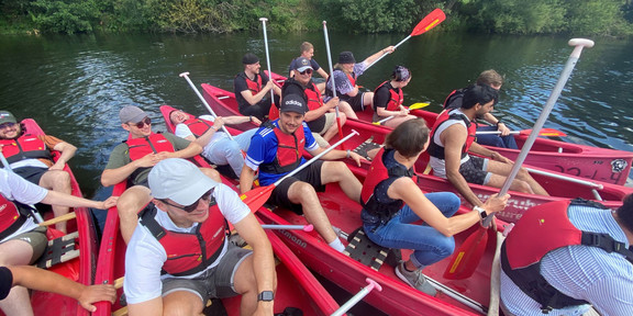 Group Photo of 5 Canoes on a river with several people