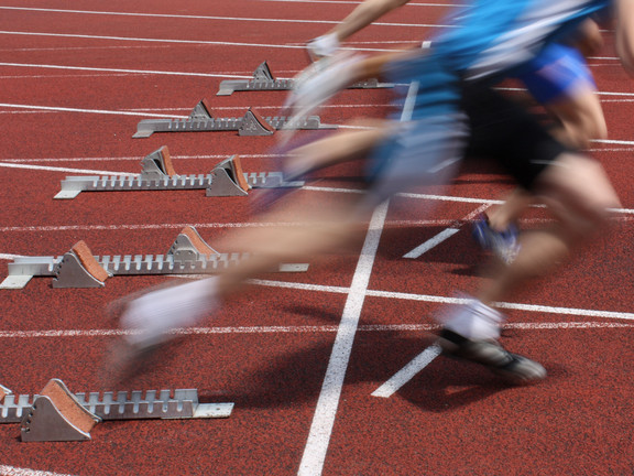 Several Sprinter are starting side by side from starting blocks.